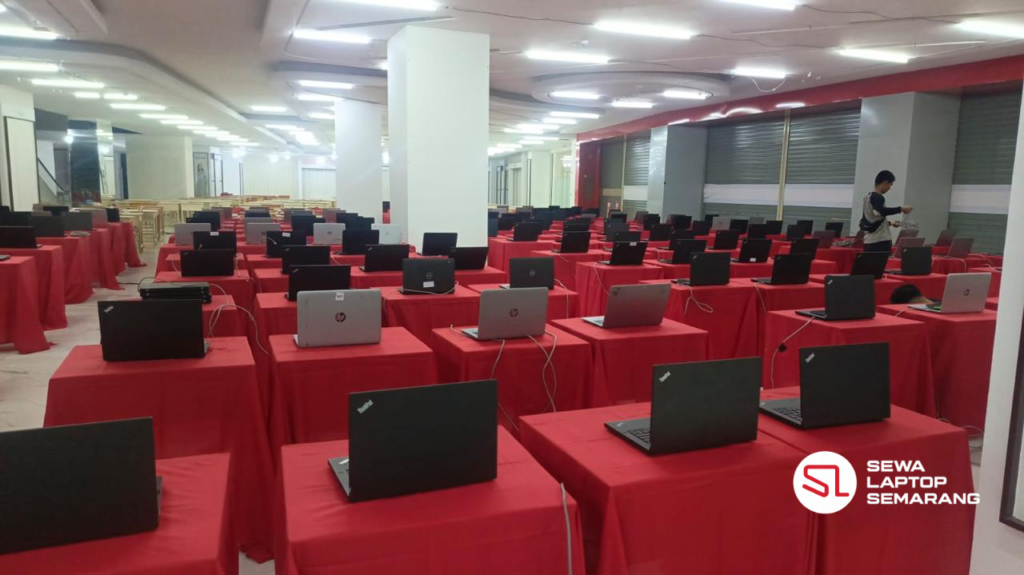 Laptop diletakkan di meja podium untuk kebutuhan event atau ujian di area gedung